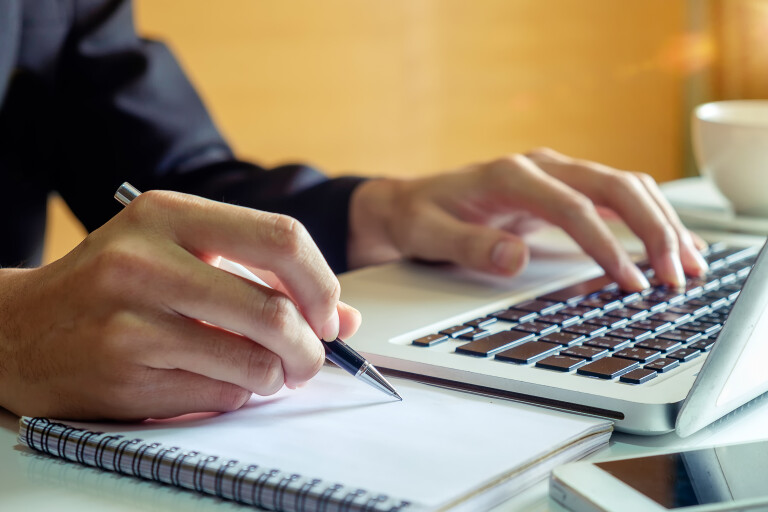 tres pessoas trabalhando num escritorio com computadores