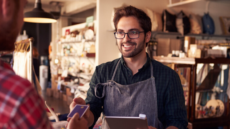 Vendedor entregando cartão para o cliente.