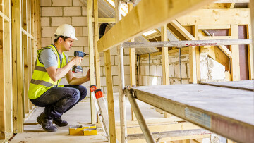 homem construindo um prédio.